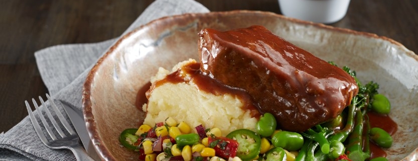 Beef Brisket plated with mashed potato and greens