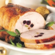 Cooked Roast Turkey sliced on a white plate with condiments