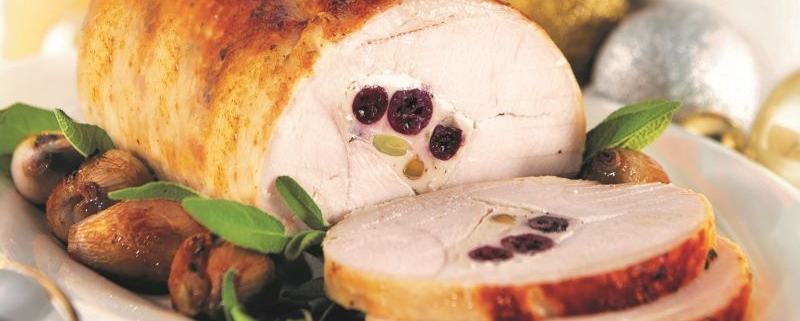 Cooked Roast Turkey sliced on a white plate with condiments